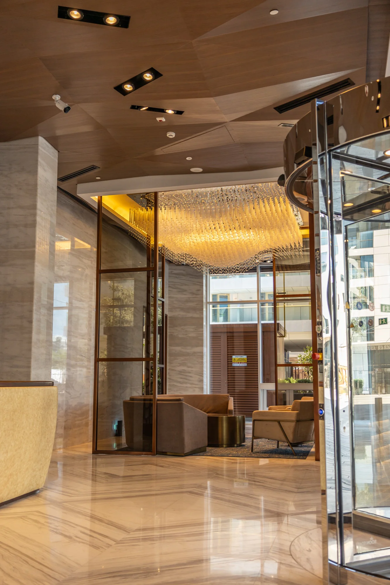 Warm marble lobby with chandelier and seating at Hidd Al Saadiyat